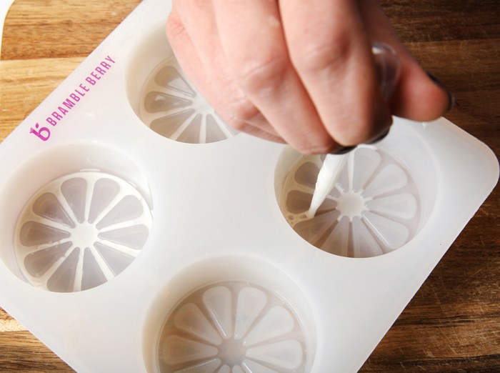 piping melt and pour soap into a citrus
                mold | Bramble Berry