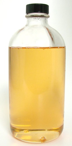 A bottle of fixed
                fragrance oil. The oil inside is liquid, clear, and homogenous