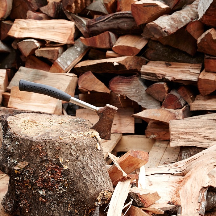 A stack of wood, featuring a stump with an axe in it in the foreground A
stack of wood, featuring a stump with an axe in it in the foreground