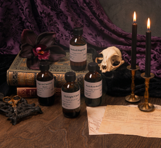 fragrance bottles with candles, skull, and old books