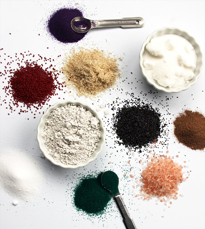 Exfoliants for Scrubs piles of
multicolored powder exfoliants on a white surface