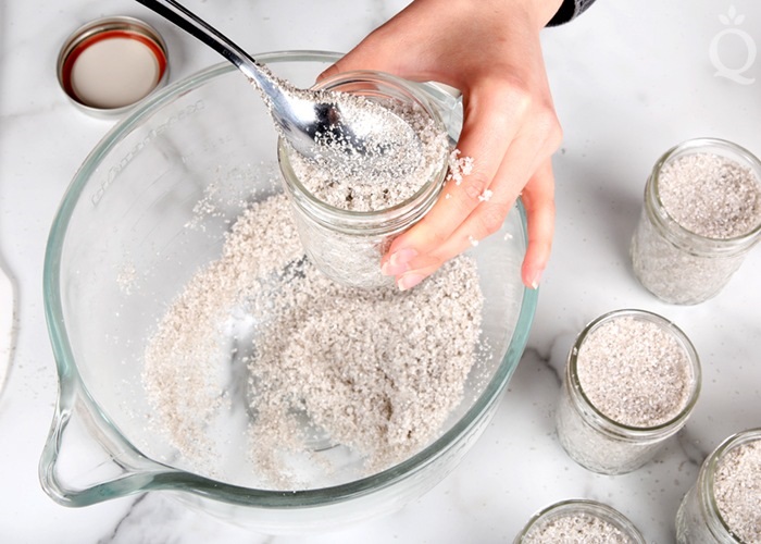 Packaging Scrub in Jars Scooping a grey scrub into glass jars