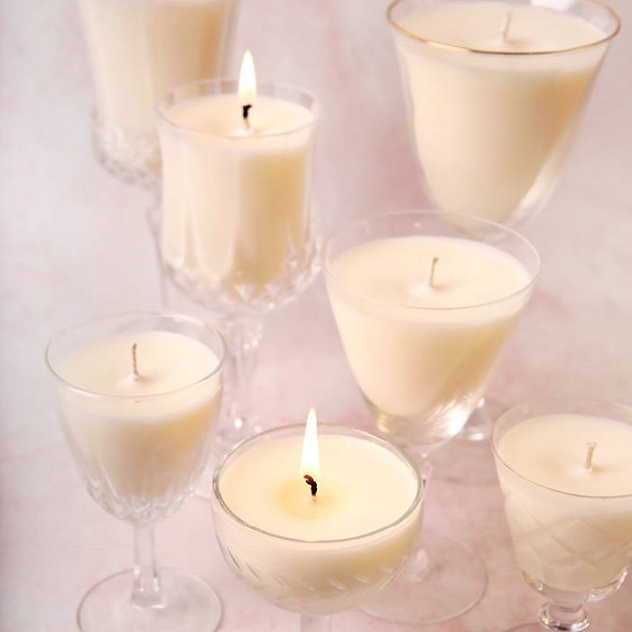 Candles in clear stem glasses, some lit